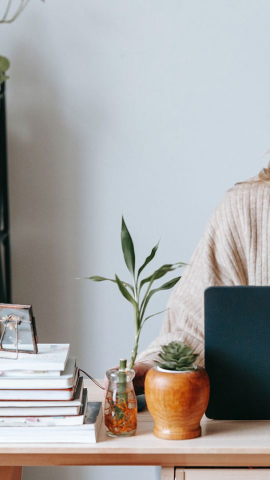 a woman sitting at a desk with a laptop at The Zeke