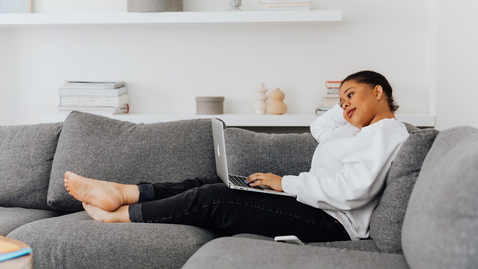 woman sitting on couch with laptop at The Zeke