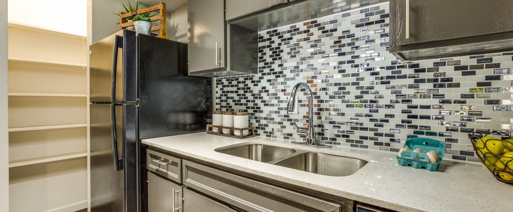 a kitchen with stainless steel appliances and tile backsplash at The Zeke