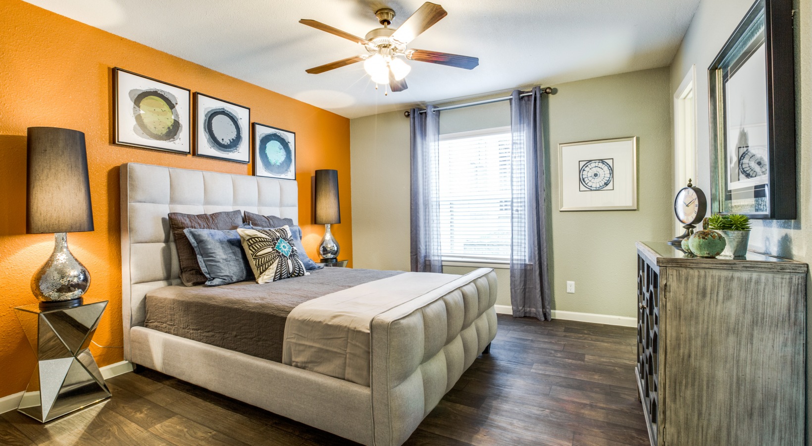 a bedroom with orange walls and hardwood floors at The Zeke