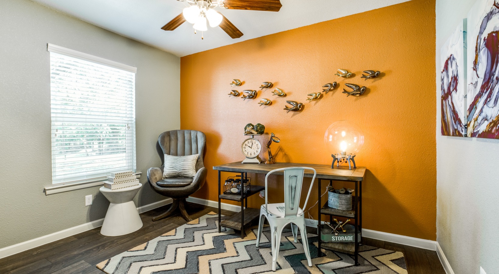 a home office with orange walls and a chevron rug at The Zeke