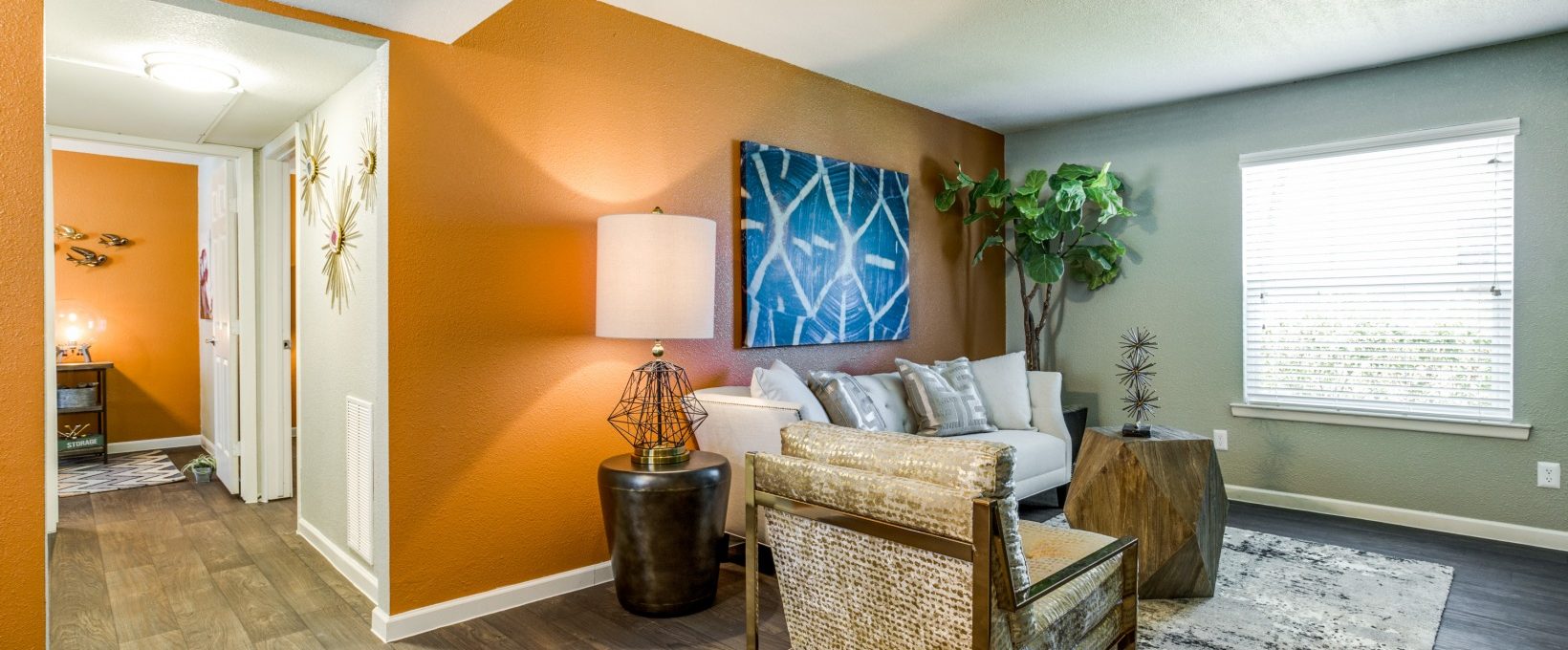 a living room with orange walls and hardwood floors at The Zeke