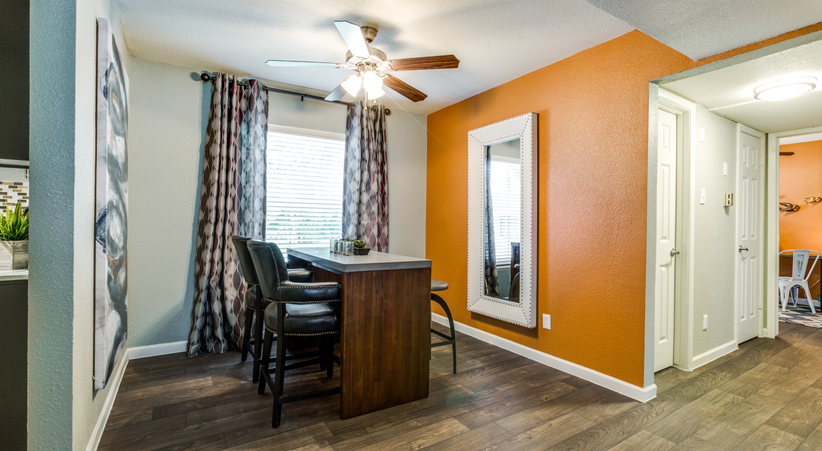 a kitchen with an orange wall and wooden floors at The Zeke