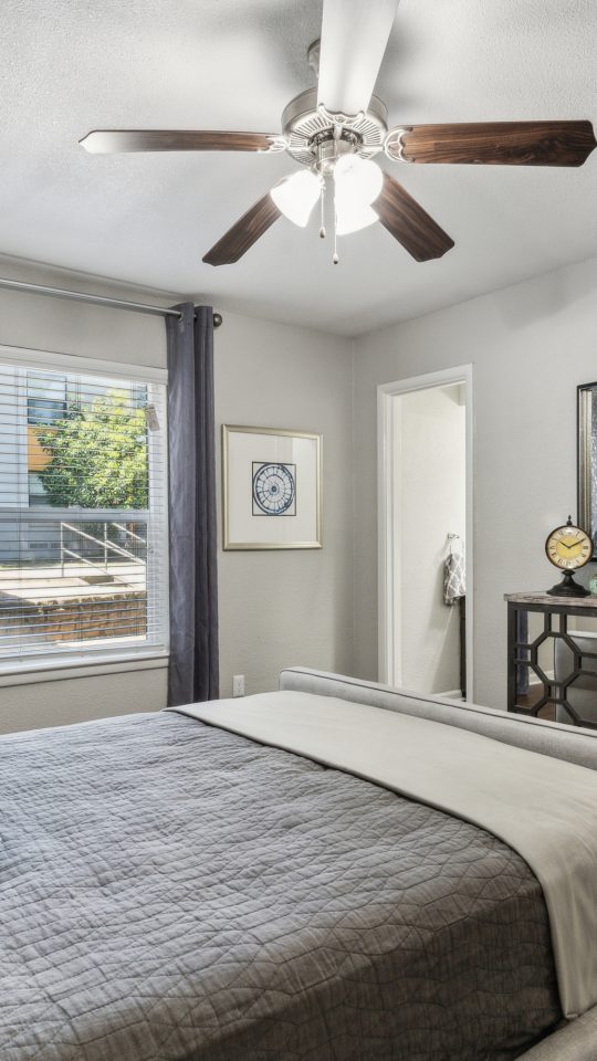 a bedroom with a ceiling fan and hardwood floors at The Zeke