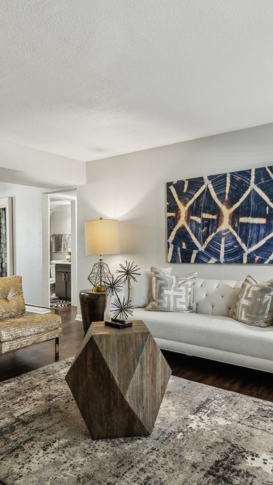 a living room with hardwood floors and a large picture window at The Zeke
